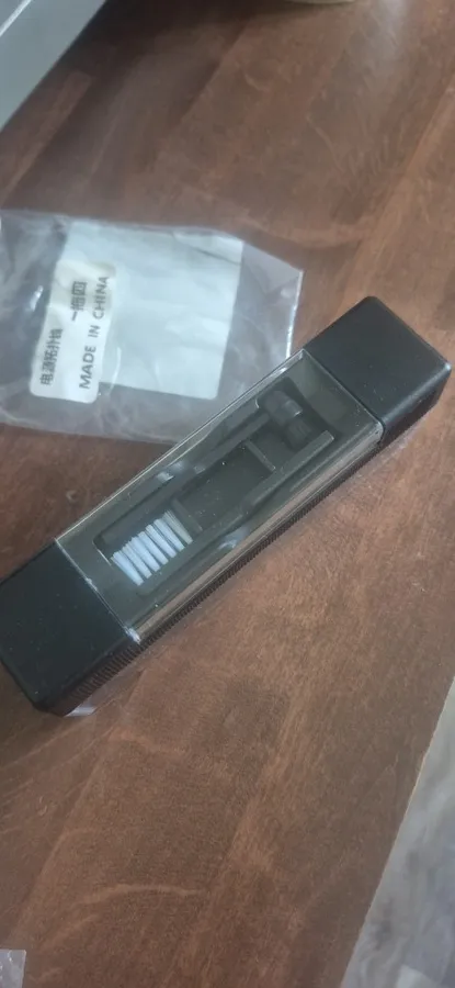 Velvet block with its clear cover on a dark wood table, next to the sealed bag it shipped in